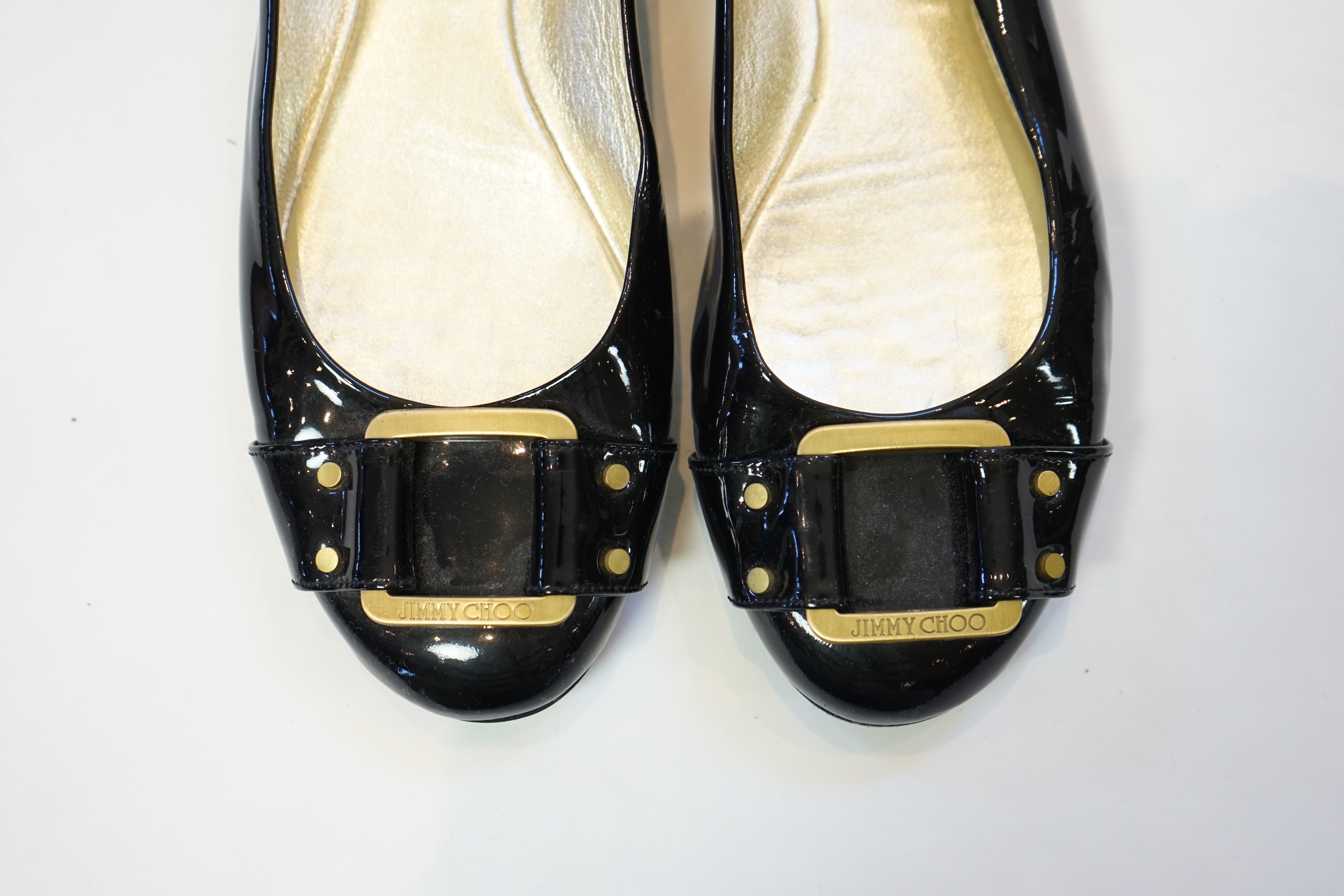 A pair of Jimmy Choo lady's black patent leather pumps with gold buckle, size EU 39